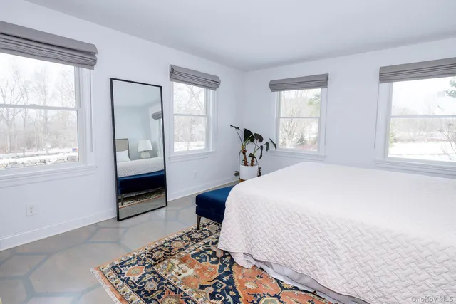 a bedroom with a bed and a lamp on dresser