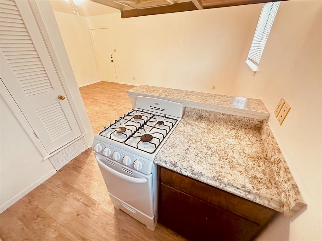 4204 Speedway, Unit 203 Austin, TX 78751 - Photo 5 of 10 Kitchen featuring light wood finished floors, white gas stove, and light stone countertops