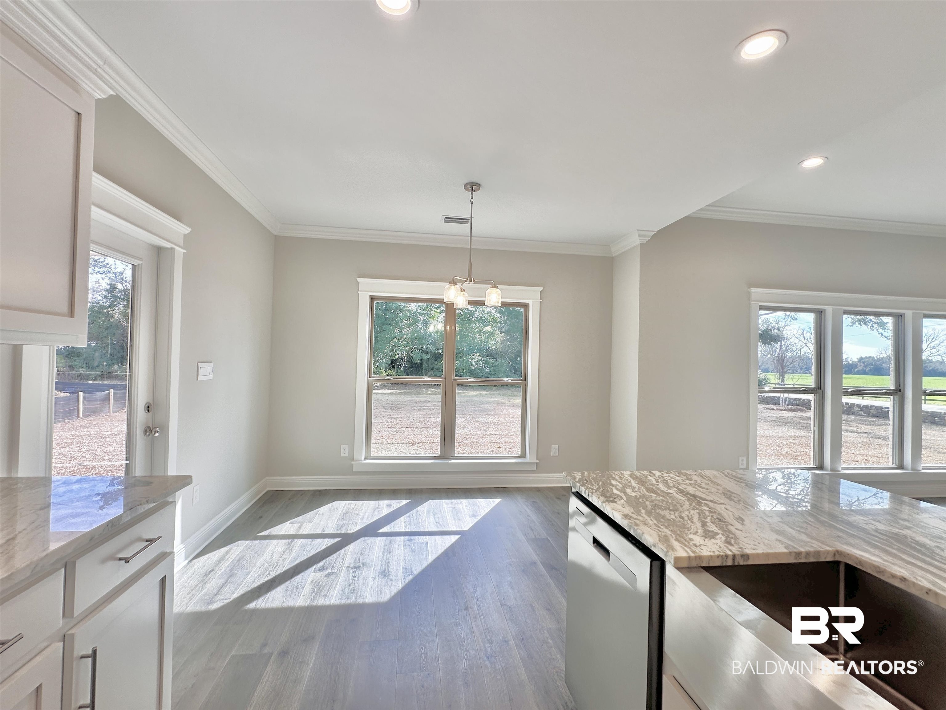 630 Kitfox Avenue Fairhope, AL 36532 - Photo 9 of 40 Kitchen featuring dishwasher, light stone counters, light hardwood / wood-style floors, white cabinets, and decorative light fixtures