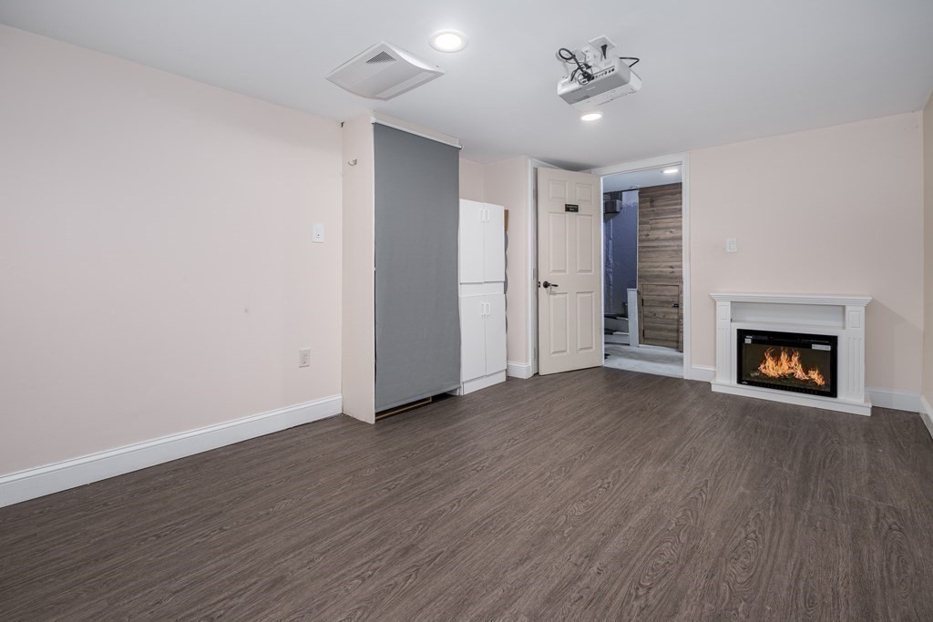 32 Tufts Road Winchester, MA 01890 - Photo 18 of 24 a view of an empty room with wooden floor fireplace and a window
