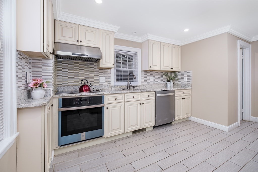 32 Tufts Road Winchester, MA 01890 - Photo 4 of 24 a kitchen with stainless steel appliances granite countertop a stove sink and cabinets