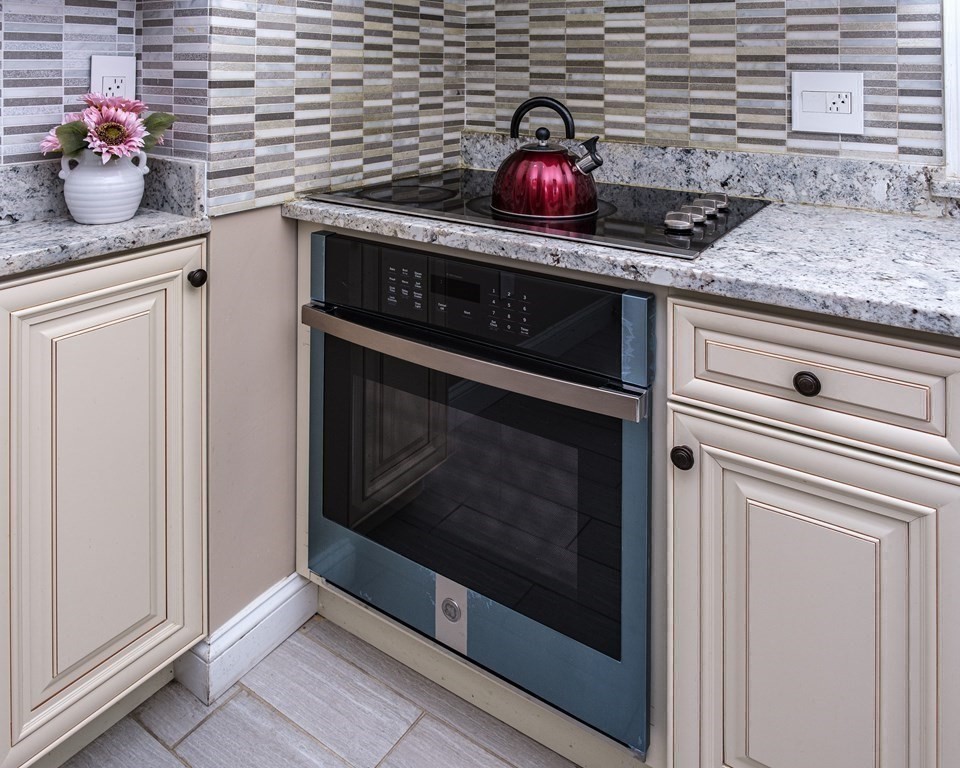 32 Tufts Road Winchester, MA 01890 - Photo 6 of 24 a kitchen with granite countertop cabinets and a stove