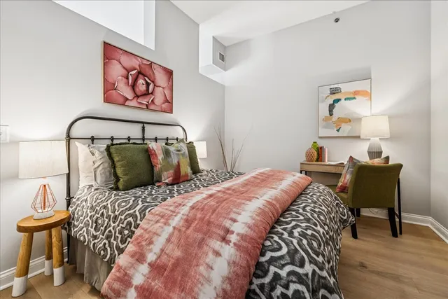 a bedroom with a bed and wooden floor