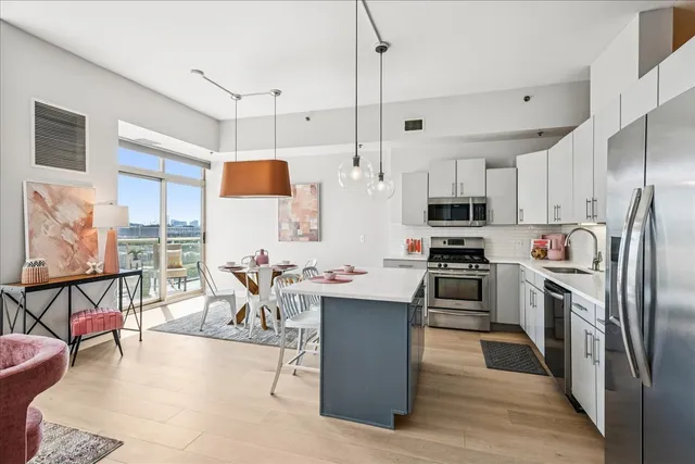 a kitchen with stainless steel appliances kitchen island granite countertop a sink a stove and a refrigerator