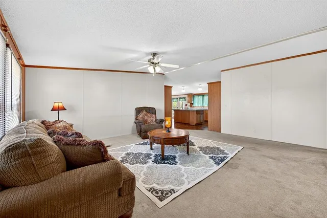 a kitchen with stainless steel appliances granite countertop a refrigerator a sink dishwasher a stove and white countertops with wooden floor