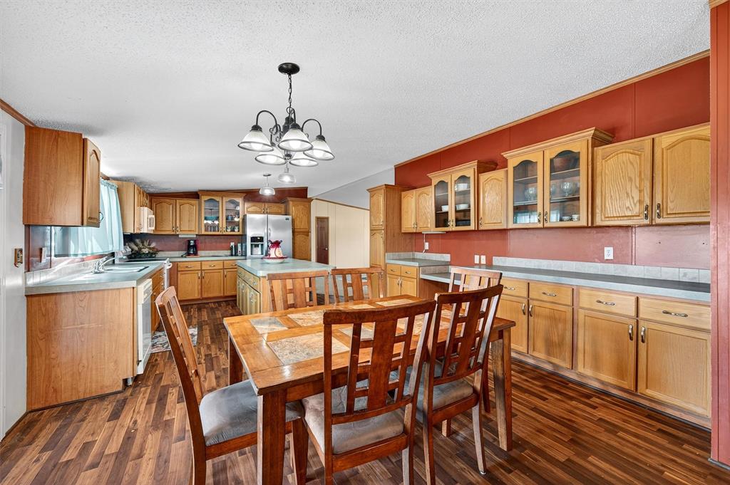 12085 Keys Road Marietta, OK 73448 - Photo 29 of 40 a dining room with furniture a chandelier and wooden floor