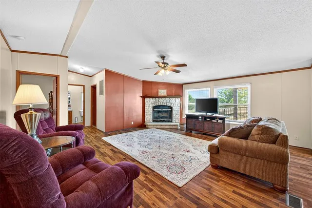 a living room with furniture a flat screen tv and kitchen view