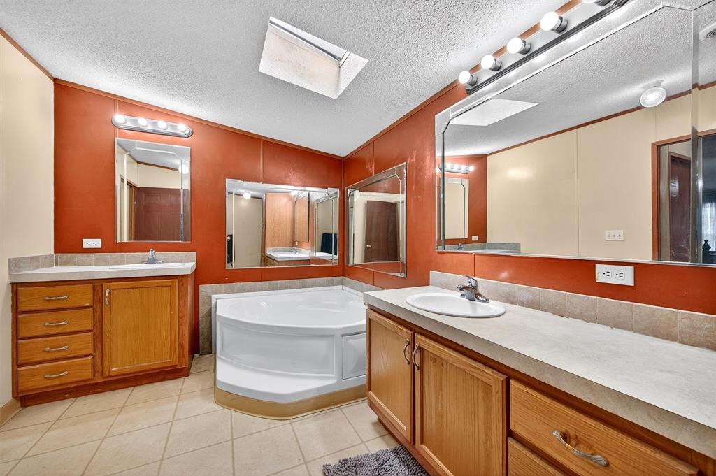 12085 Keys Road Marietta, OK 73448 - Photo 37 of 40 a bathroom with a granite countertop sink and a mirror