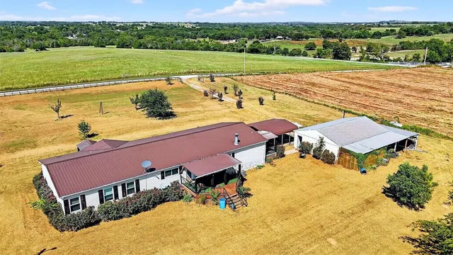 an aerial view of a house with a yard and lake view
