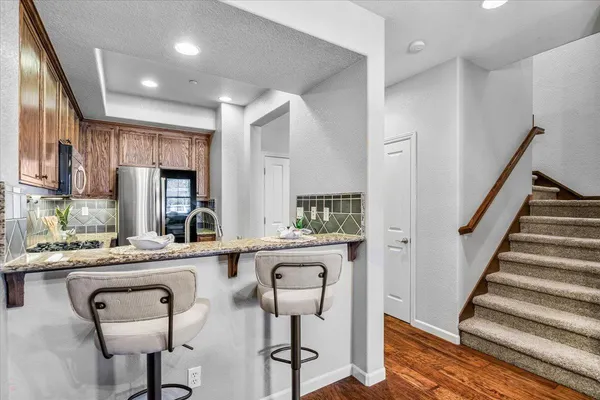 a kitchen with stainless steel appliances granite countertop a refrigerator and a stove top oven