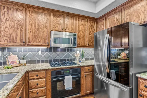 a kitchen with stainless steel appliances granite countertop a stove a refrigerator and a microwave