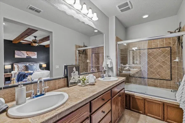 a bathroom with a granite countertop sink a toilet a mirror and shower