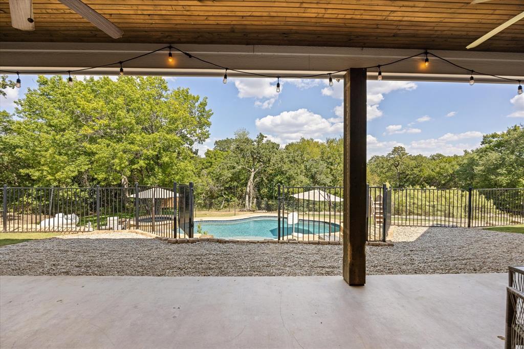 3868 Legend Trail Granbury, TX 76049 - Photo 29 of 39 Enjoy the view from the shade of this oversized back patio. Decorative lighting, ceiling fans and room to grill.