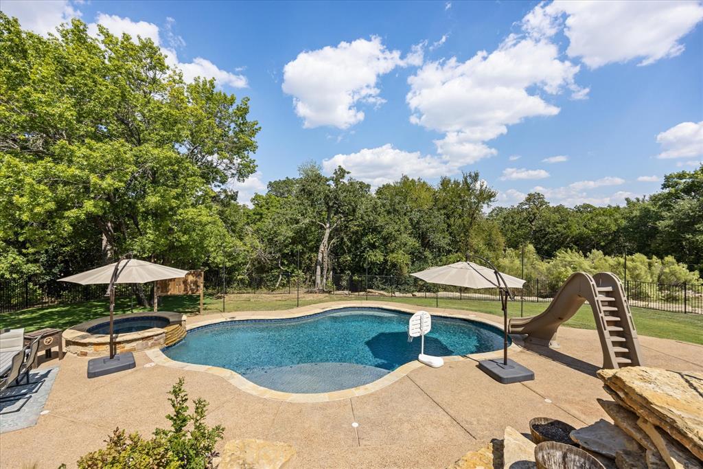 3868 Legend Trail Granbury, TX 76049 - Photo 32 of 39 Why would you even need to leave home? Staycation is everyday all year! Heated Saltwater pool with slide and attached spa. Propane tank for pool is separate from home propane.