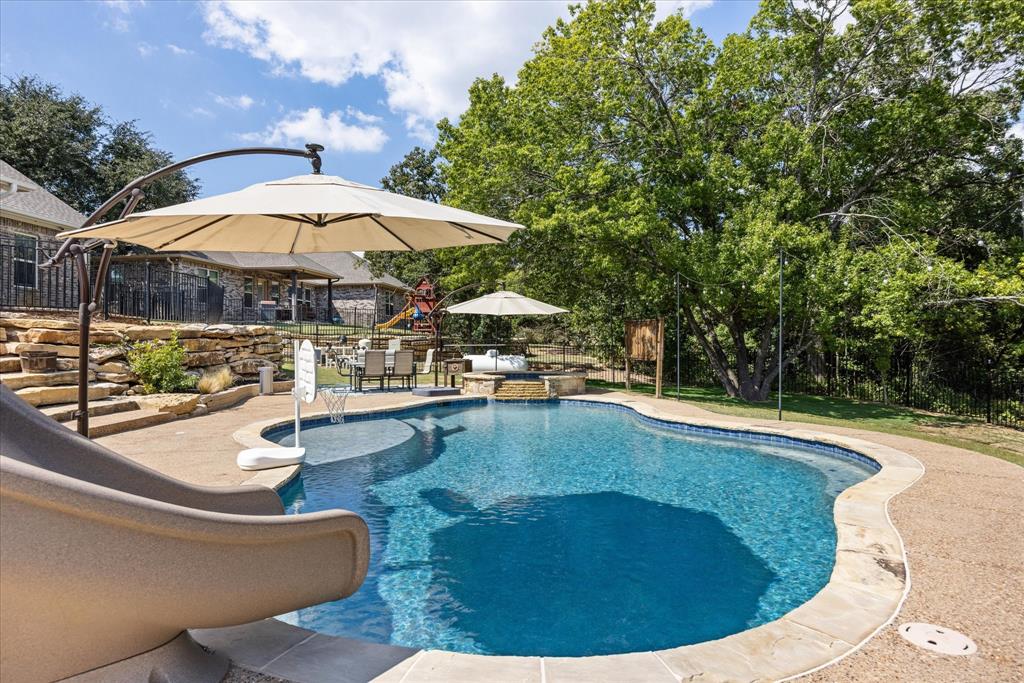 3868 Legend Trail Granbury, TX 76049 - Photo 33 of 39 Pool deck entertaining and even a covered TV off the spa. Completely fenced for safety.