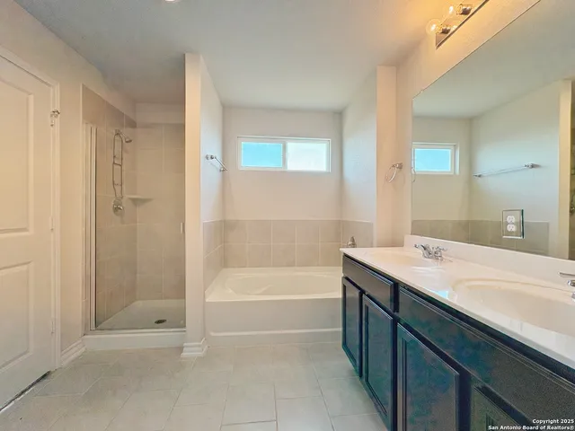 a bathroom with a tub sink shower and a mirror