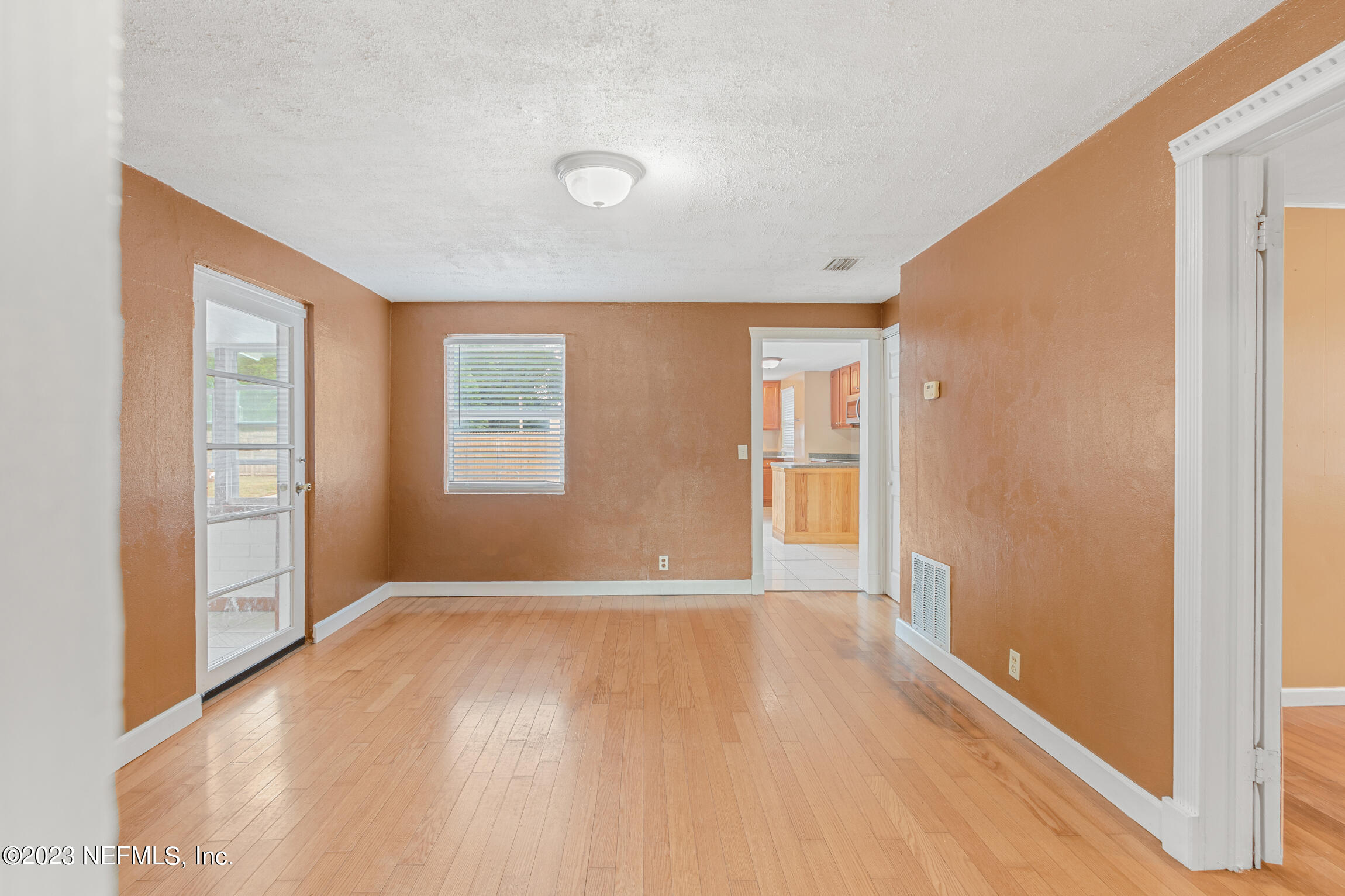 665 Lee Road Jacksonville, FL 32225 - Photo 11 of 58 a view of an empty room with wooden floor and a window