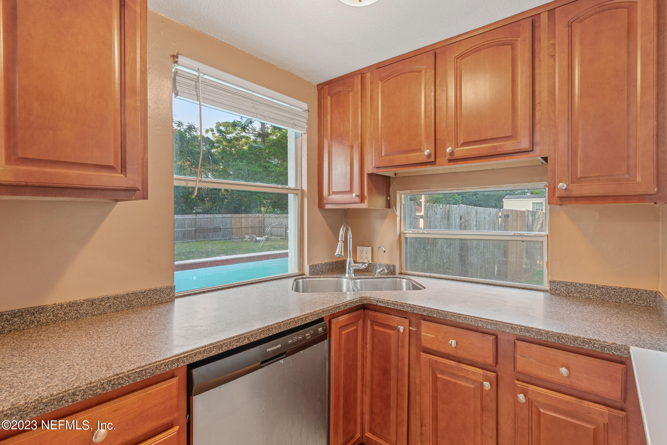 665 Lee Road Jacksonville, FL 32225 - Photo 15 of 58 a kitchen with granite countertop wooden cabinets a sink and a window