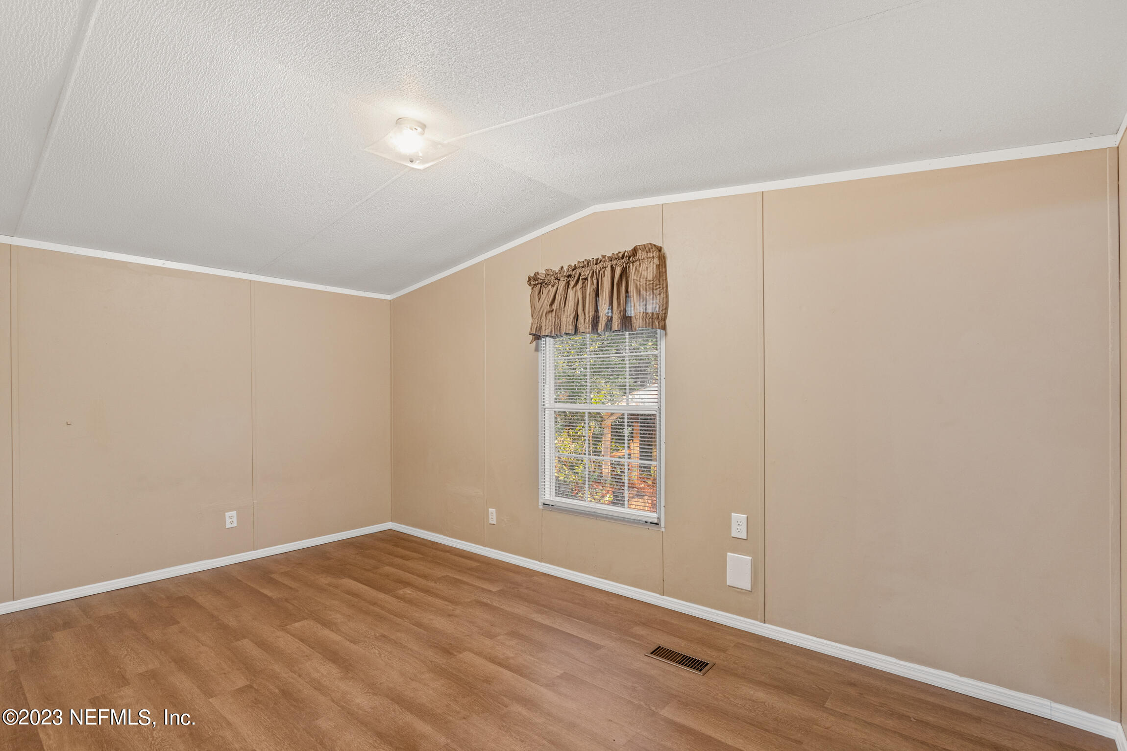 665 Lee Road Jacksonville, FL 32225 - Photo 47 of 58 a view of an empty room with wooden floor and a window