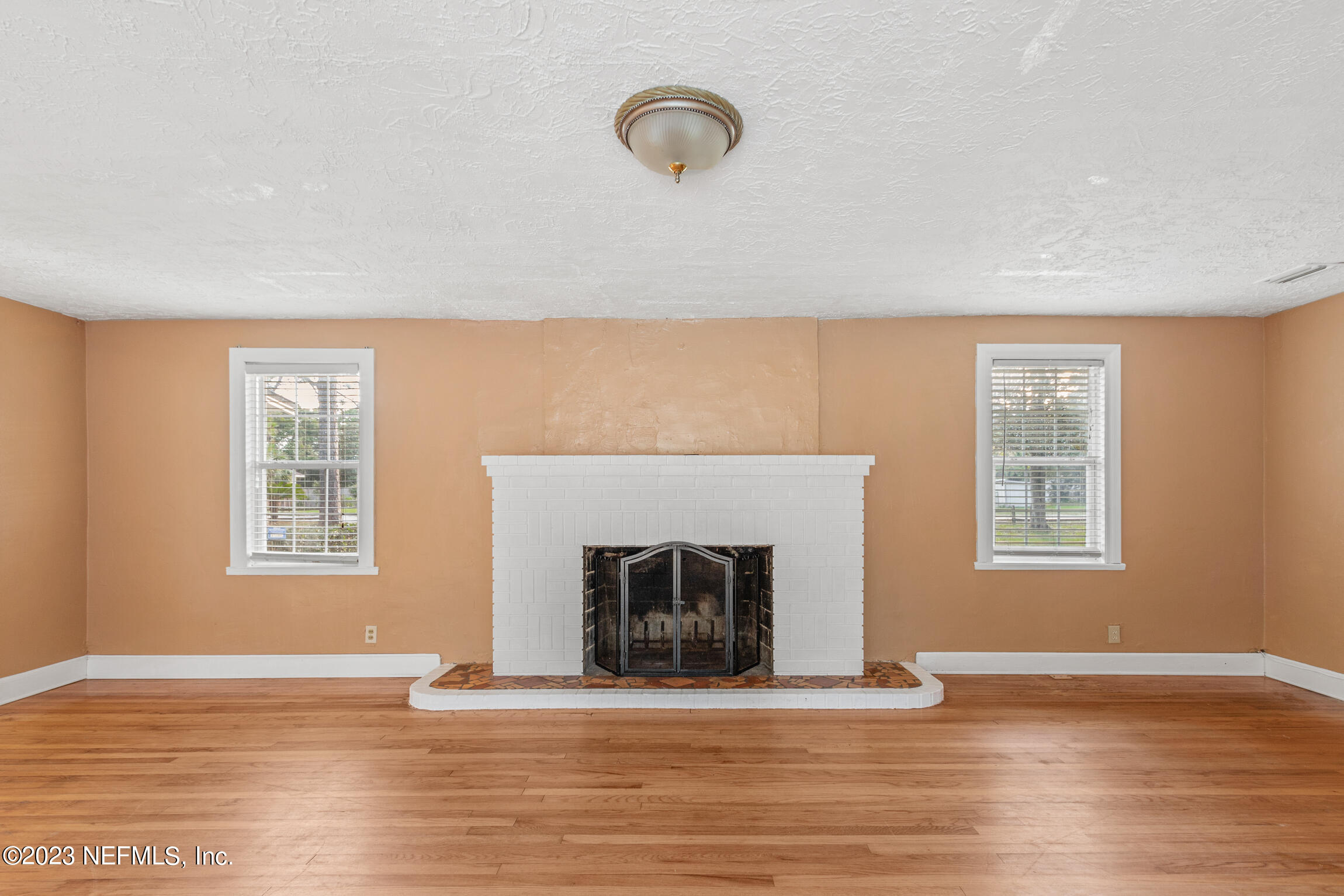 665 Lee Road Jacksonville, FL 32225 - Photo 9 of 58 a view of an empty room with wooden floor and a window