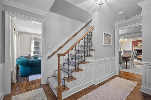 a living room with furniture and a dining table with wooden floor