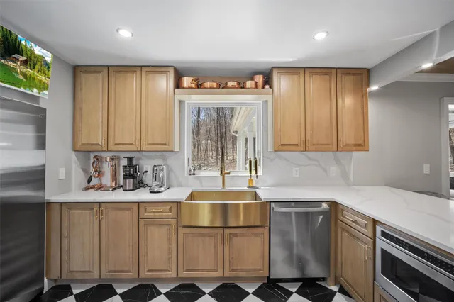 a kitchen with stainless steel appliances granite countertop a sink a stove and cabinets