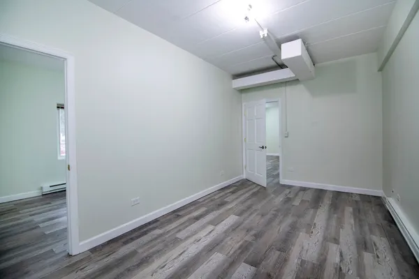 a view of a small space with wooden floor and a window