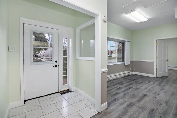 a kitchen with granite countertop a refrigerator a sink a stove and white cabinets
