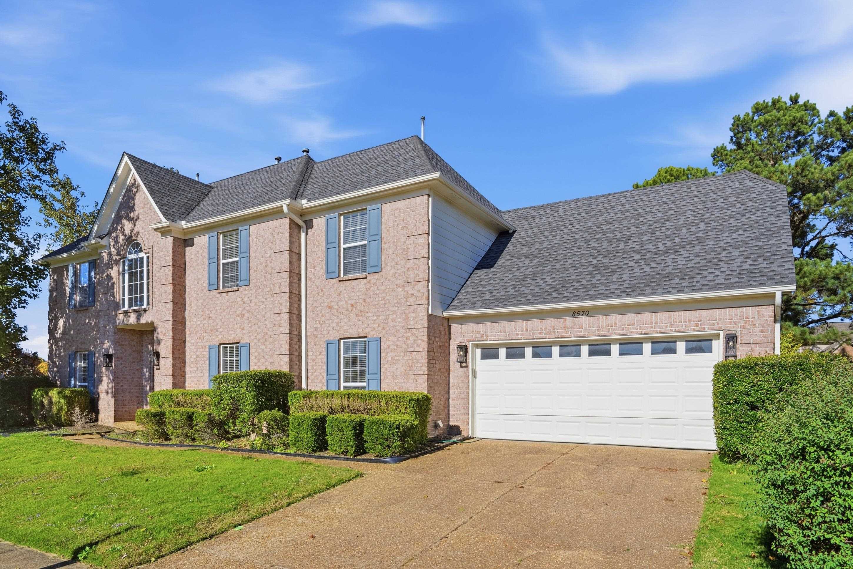 8570 May Orchard Lane Cordova, TN 38018 - Photo 2 of 35 View of front of property with a front yard, brick siding, driveway, a garage, and roof with shingles