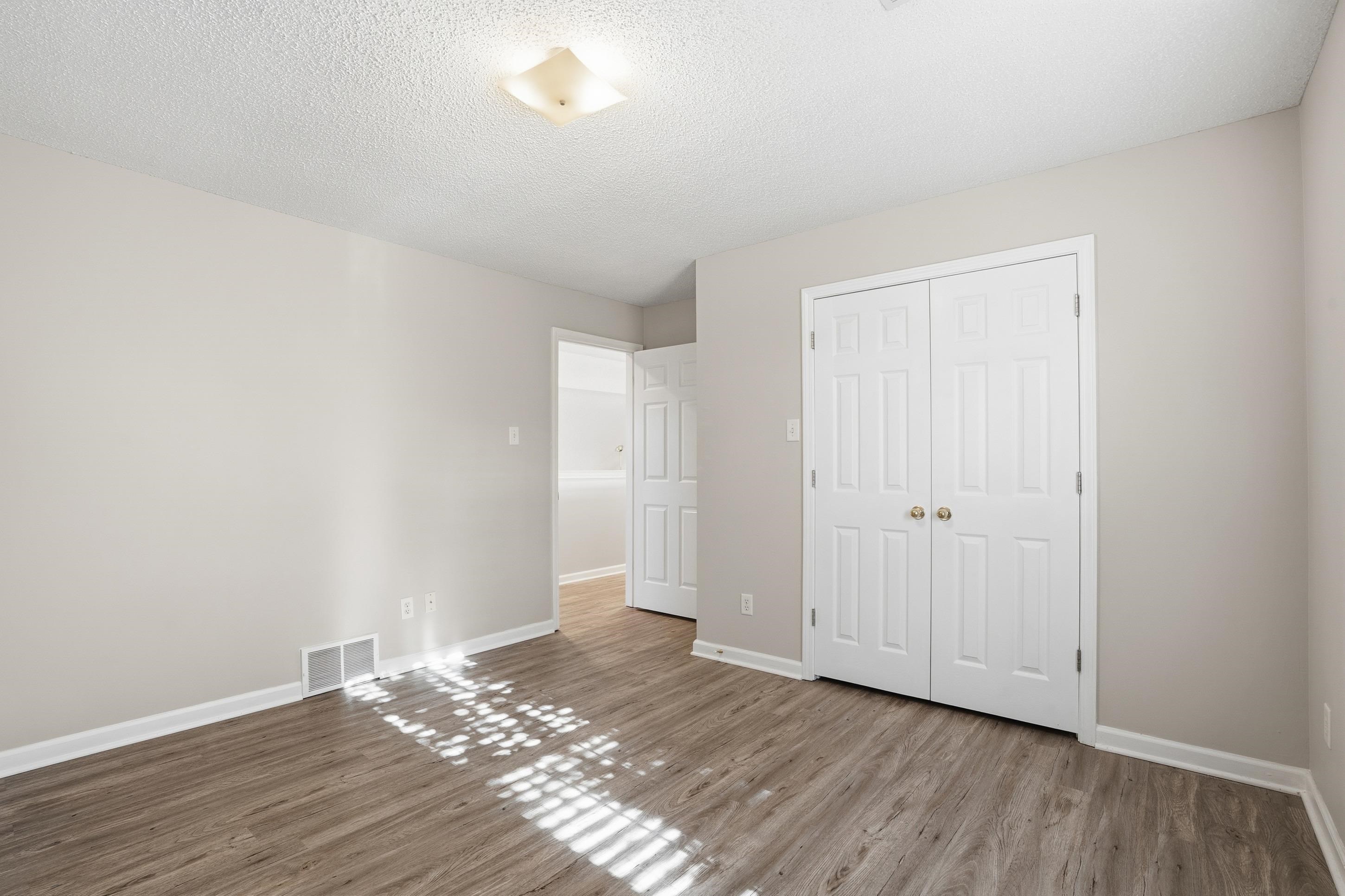 8570 May Orchard Lane Cordova, TN 38018 - Photo 23 of 35 Unfurnished bedroom featuring a textured ceiling, a closet, and wood finished floors