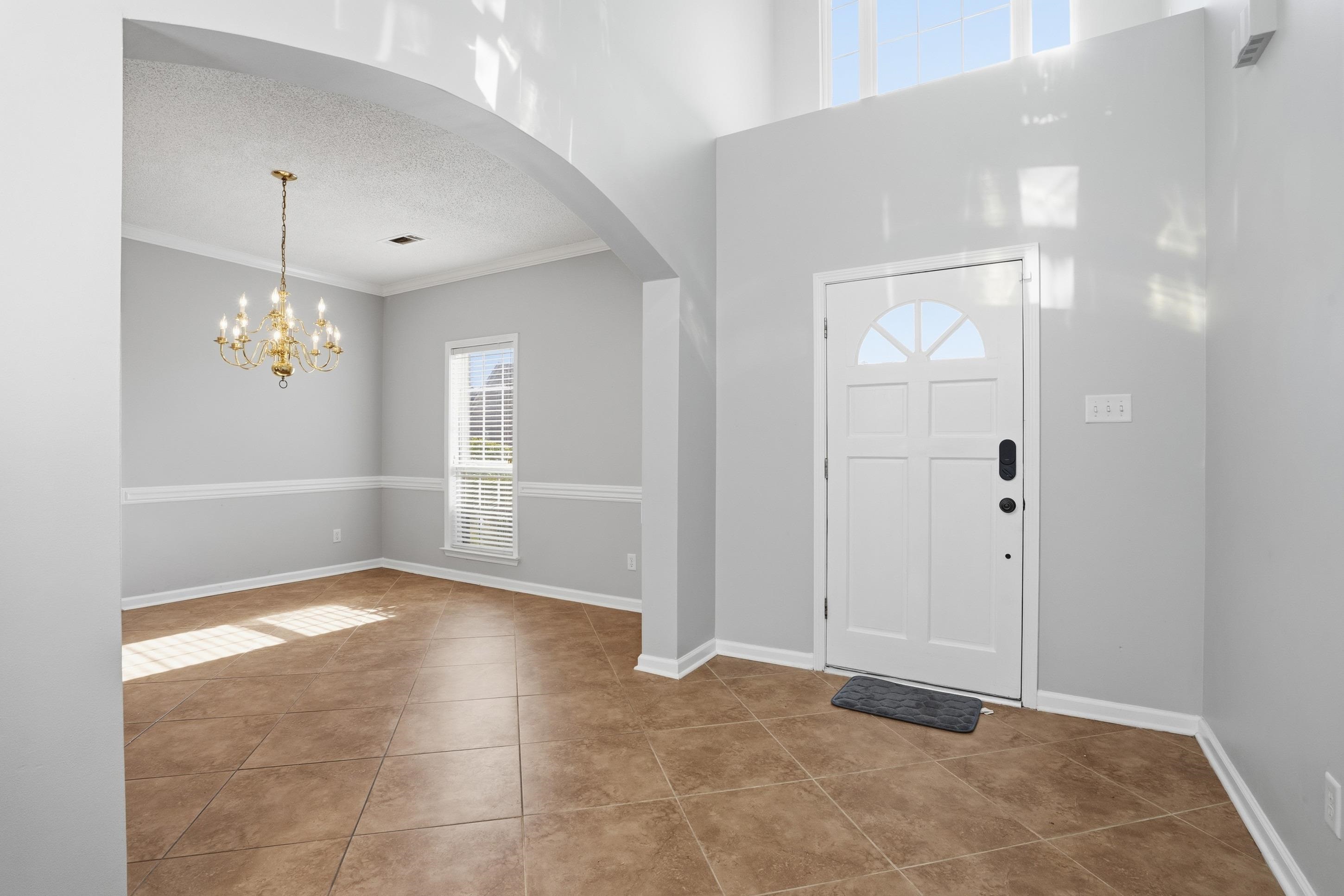 8570 May Orchard Lane Cordova, TN 38018 - Photo 5 of 35 Entrance foyer featuring arched walkways, a textured ceiling, ornamental molding, a chandelier, and tile patterned floors