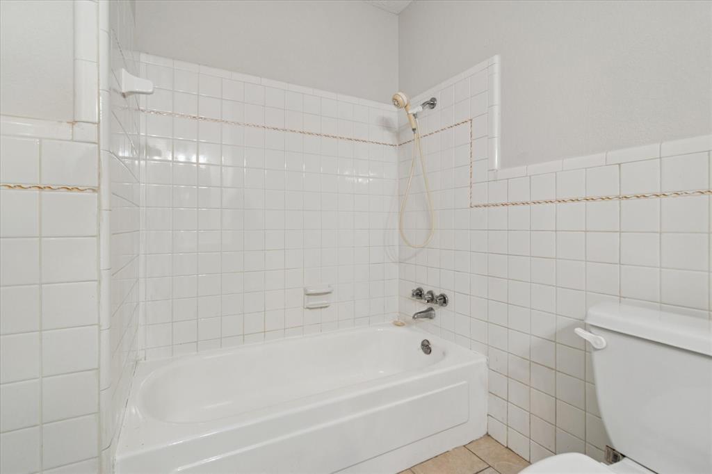 852 West Redbud Drive Hurst, TX 76053 - Photo 20 of 25 a bathroom with a bathtub and a toilet