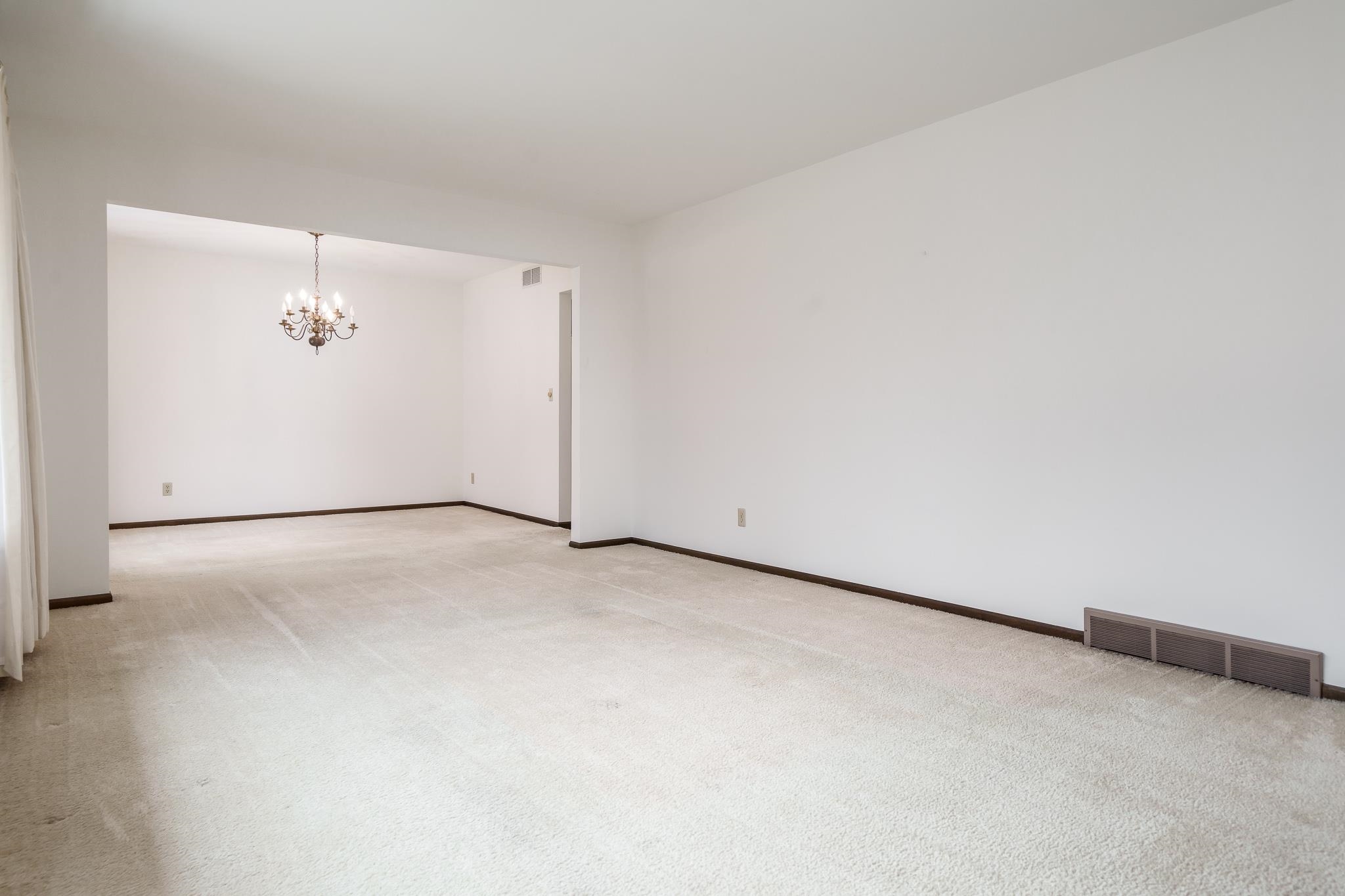 8169 Clockview Road Rockford, IL 61108 - Photo 4 of 34 an empty room with a ceiling fan and window
