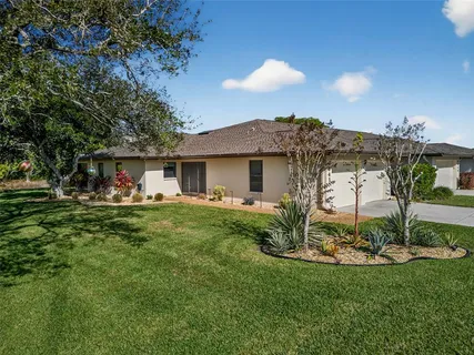a view of a house with backyard and sitting area