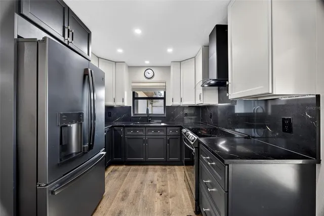 a kitchen with stainless steel appliances granite countertop a sink and a refrigerator