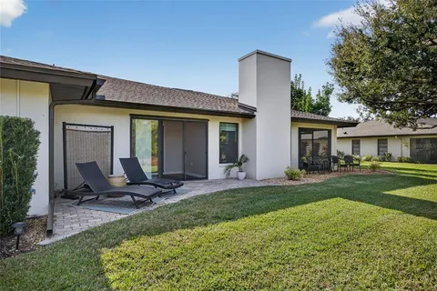 a view of a chair and table in backyard of the house