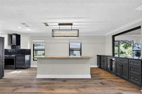 a large kitchen with wooden floors and stainless steel appliances