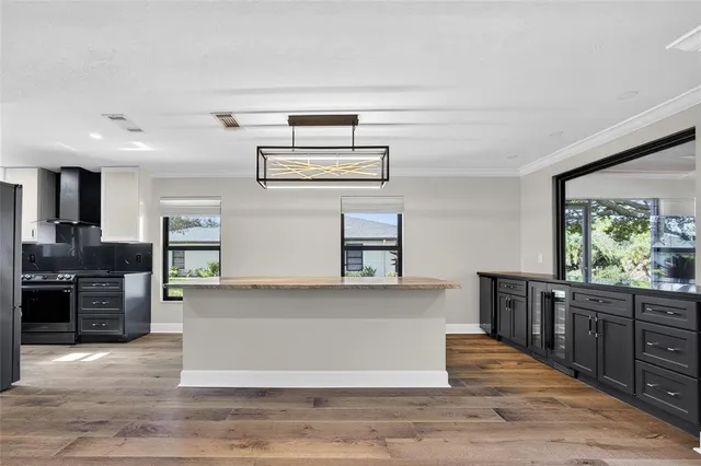 a large kitchen with wooden floors and stainless steel appliances