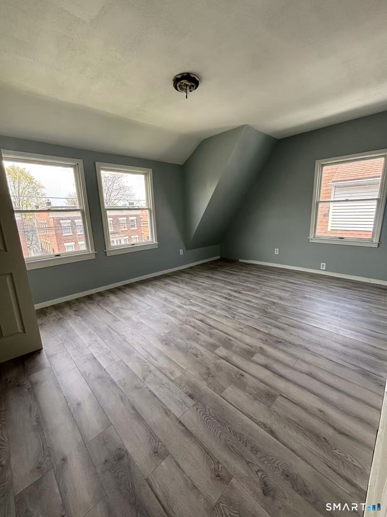 366 Dover Street Bridgeport, CT 06610 - Photo 11 of 15 an empty room with wooden floor and windows