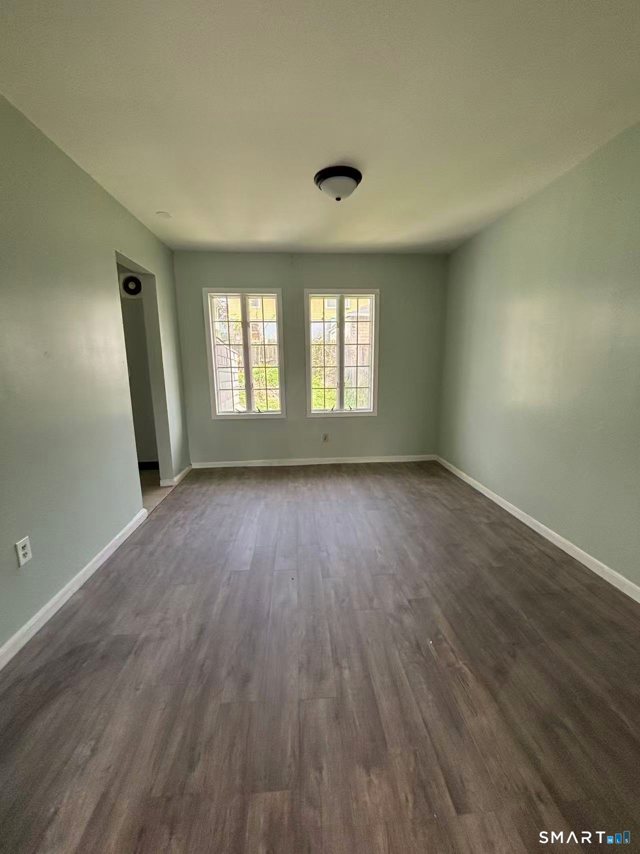 366 Dover Street Bridgeport, CT 06610 - Photo 2 of 15 an empty room with wooden floor and windows