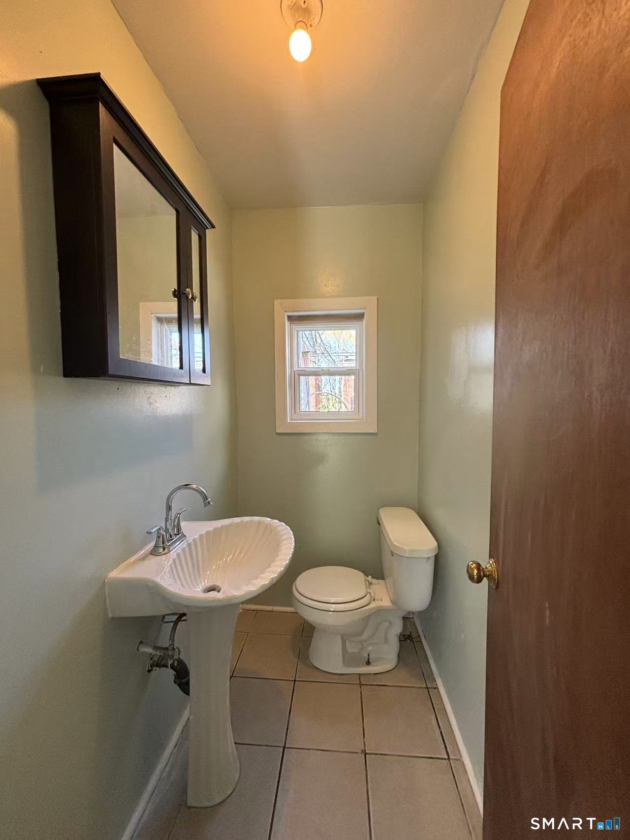 366 Dover Street Bridgeport, CT 06610 - Photo 5 of 15 a bathroom with a sink a toilet and mirror