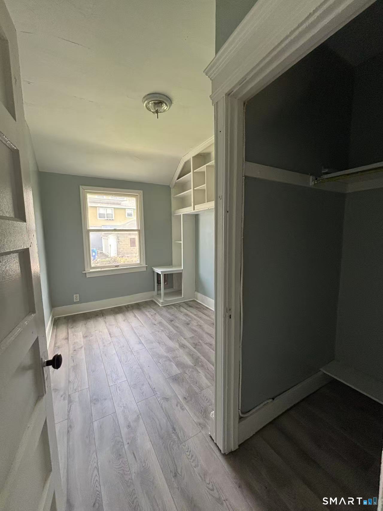 366 Dover Street Bridgeport, CT 06610 - Photo 6 of 15 an empty room with wooden floor and windows