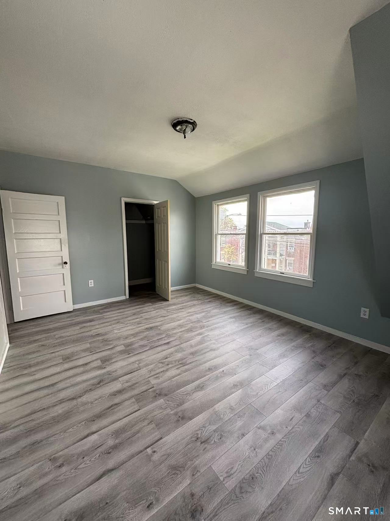 366 Dover Street Bridgeport, CT 06610 - Photo 7 of 15 an empty room with wooden floor and windows