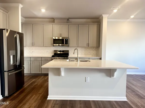 a kitchen with stainless steel appliances a sink a stove a refrigerator and cabinets