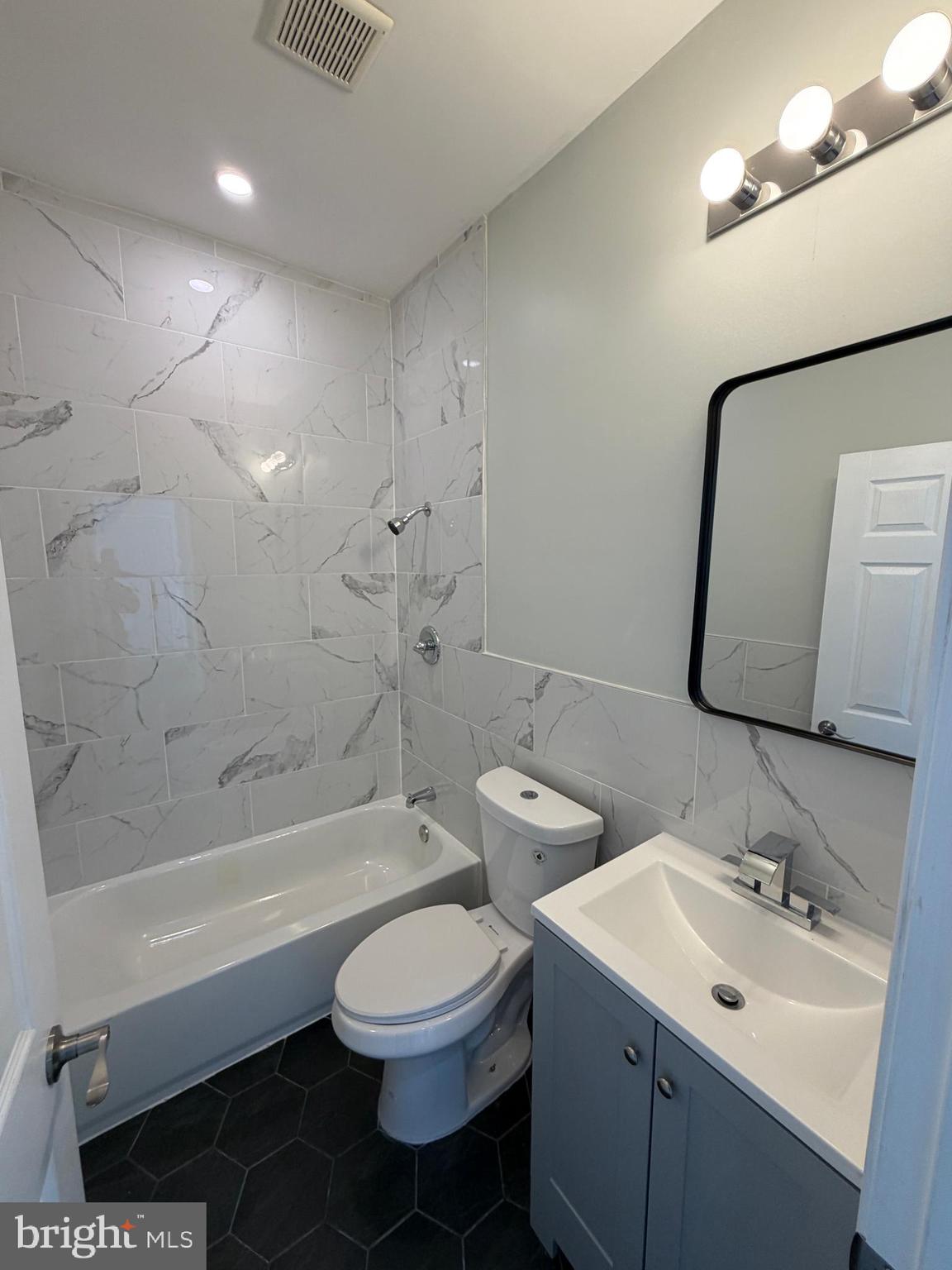 6035 Germantown Avenue, Unit 3R Philadelphia, PA 19144 - Photo 10 of 12 a bathroom with a double vanity sink toilet mirror and bathtub