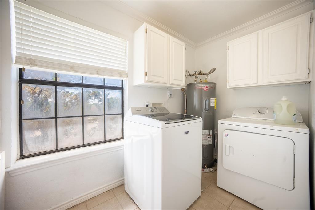 2835 Keller Springs Road, Unit 808 Carrollton, TX 75006 - Photo 11 of 16 Clothes washing area with water heater, washer and clothes dryer, light tile patterned floors, and cabinet space