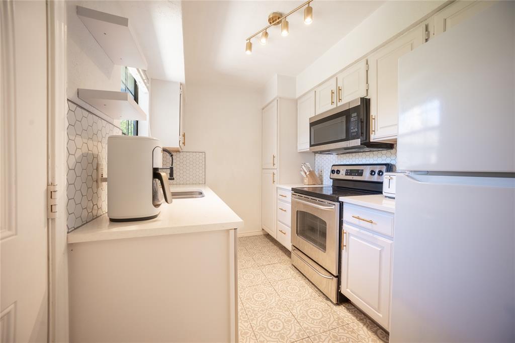 2835 Keller Springs Road, Unit 808 Carrollton, TX 75006 - Photo 16 of 16 Kitchen featuring stainless steel appliances, backsplash, light countertops, a sink, and light tile patterned flooring