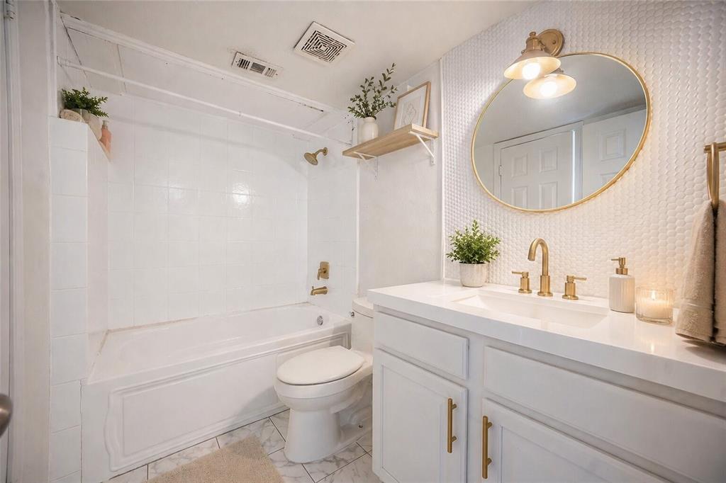 2835 Keller Springs Road, Unit 808 Carrollton, TX 75006 - Photo 3 of 16 White vanity with gold-tone hardware and integrated sink