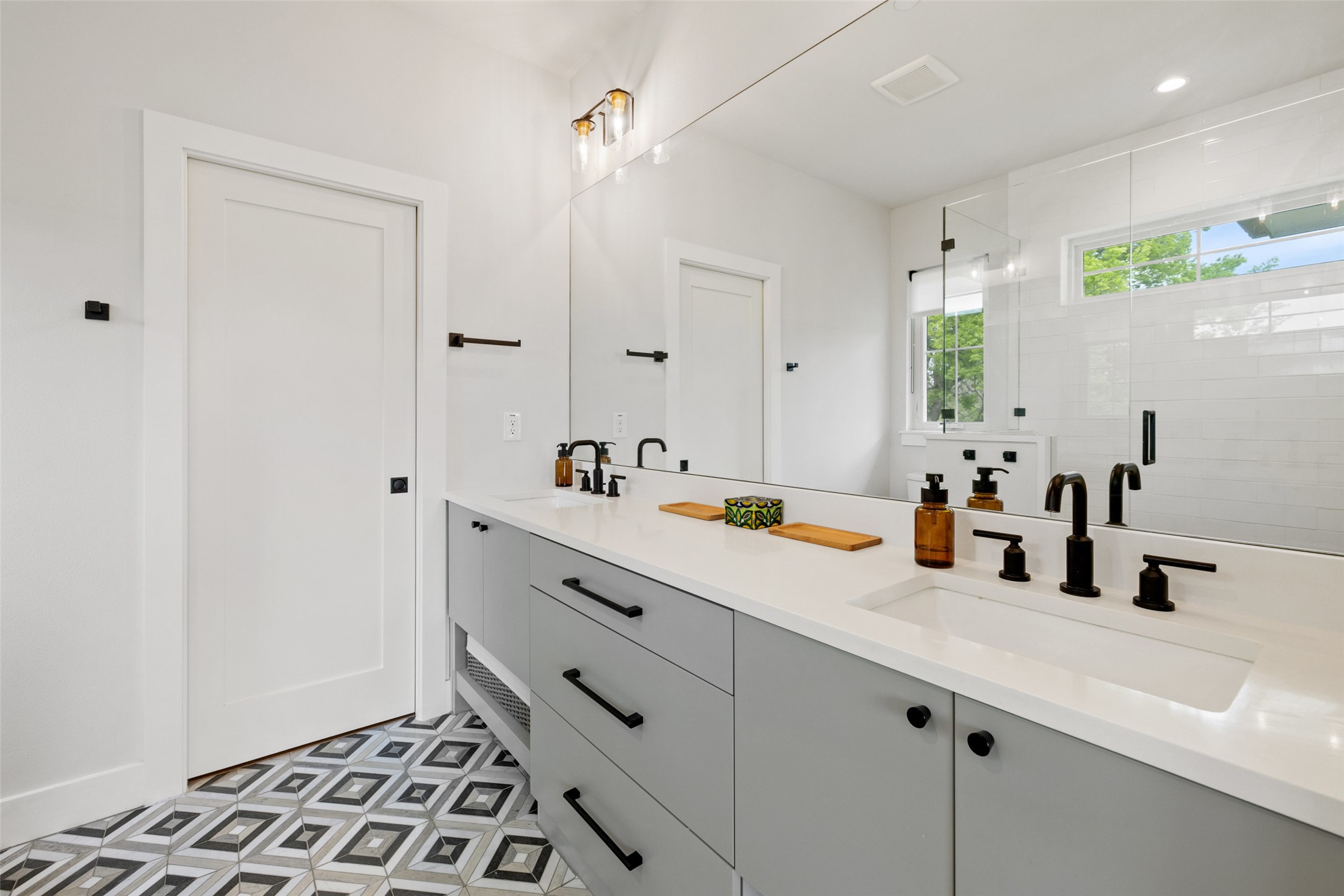 1504 Ruth Avenue, Unit 3 Austin, TX 78757 - Photo 22 of 39 A striking patterned tile floor leads to a sleek vanity with modern fixtures.