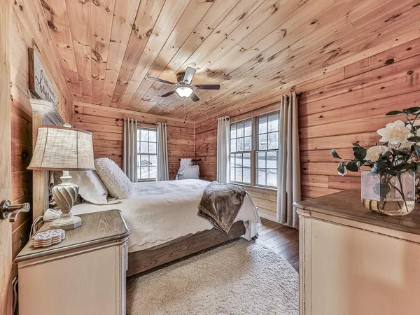 a bedroom with a bed lamp and wooden floor